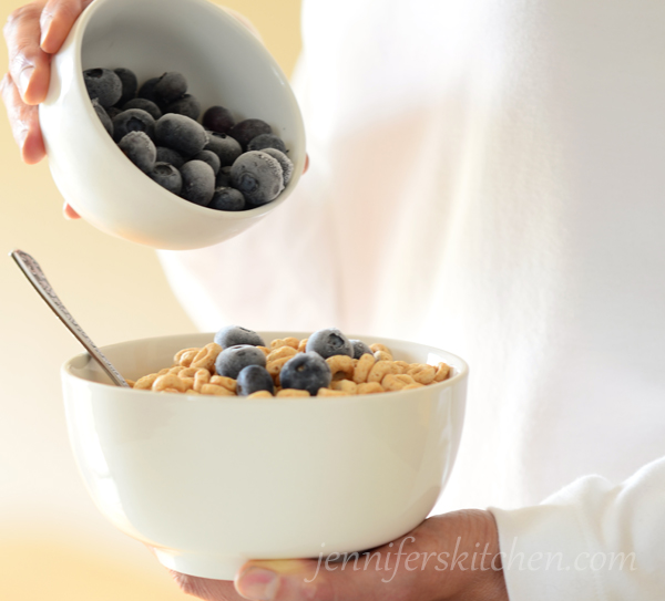 Pouring blueberries on cereal for a Healthier Morning meal