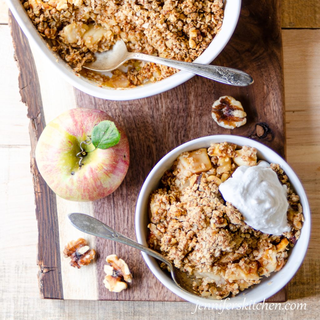 Sugar-Free Apple Crisp in a bowl with cream on top.