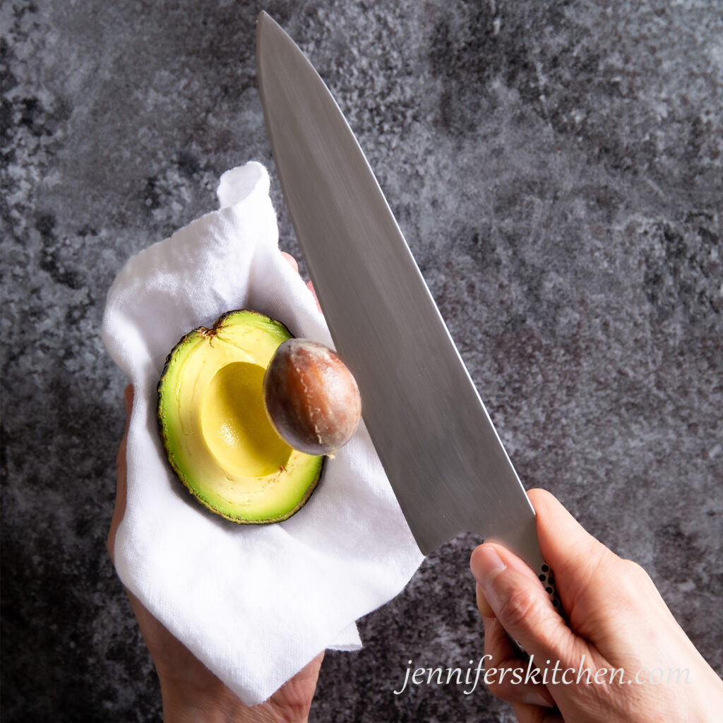 Lifting pit out of cut avocado half