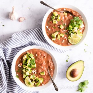Slow-Cooker/Crock-Pot Home Cooked Pinto Beans in two bowls topped with avocado