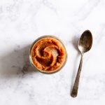 A jar of date paste with a spoon.