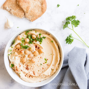 Oil-free hummus topped with fresh parsley, garlic, and chickpeas.