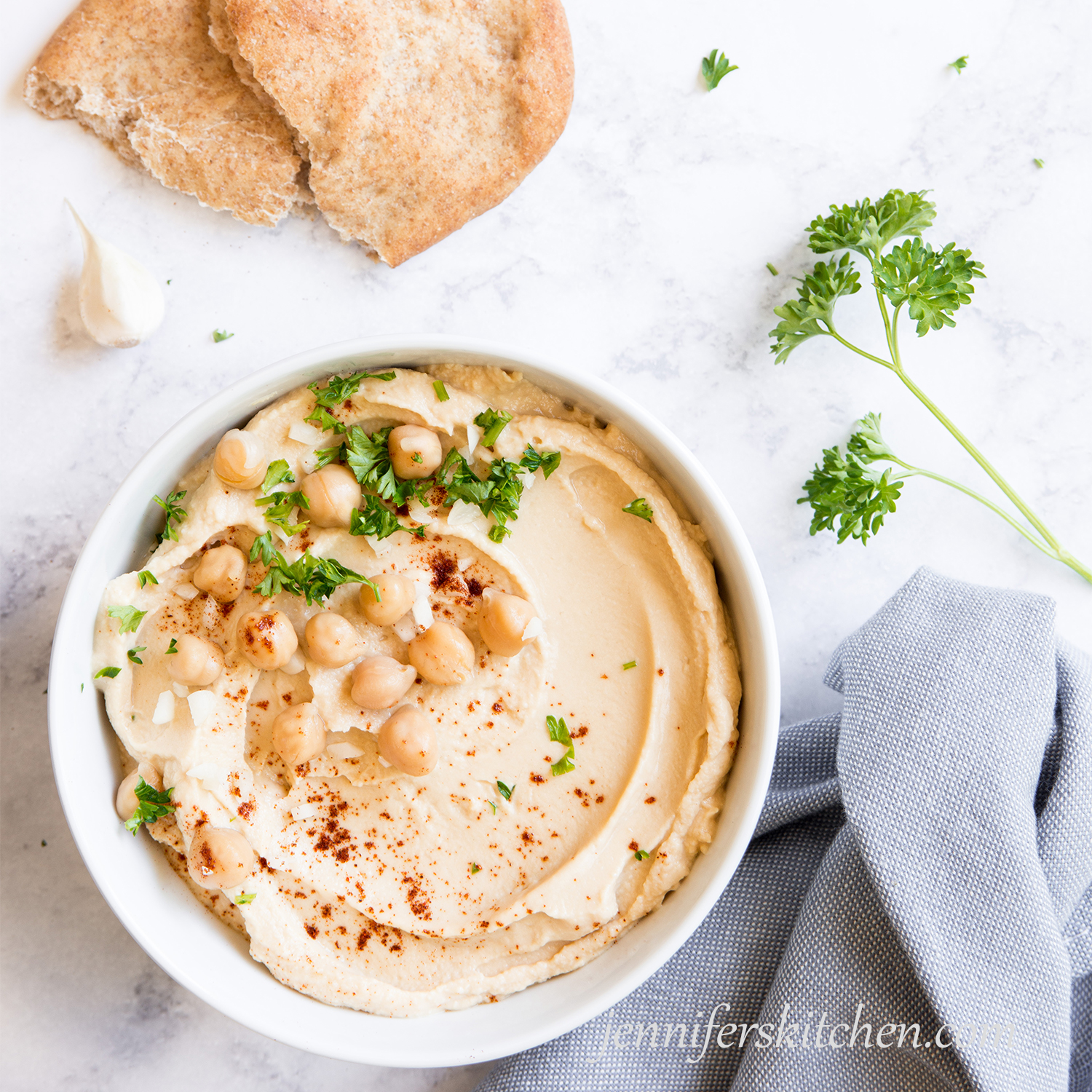 Oil-free hummus topped with fresh parsley, garlic, and chickpeas.