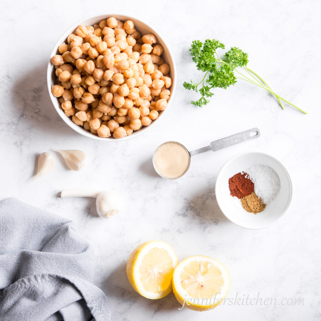 Oil-free hummus ingredients - chickpeas, tahini, fresh garlic, fresh lemon, and seasonings.