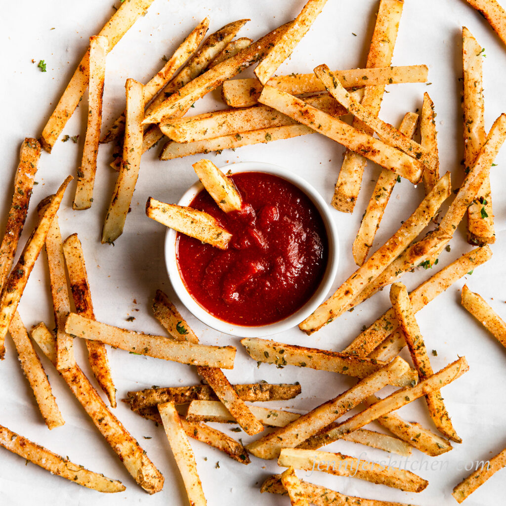 Oil-free baked fries with homemade, vinegar-free ketchup in a bowl.