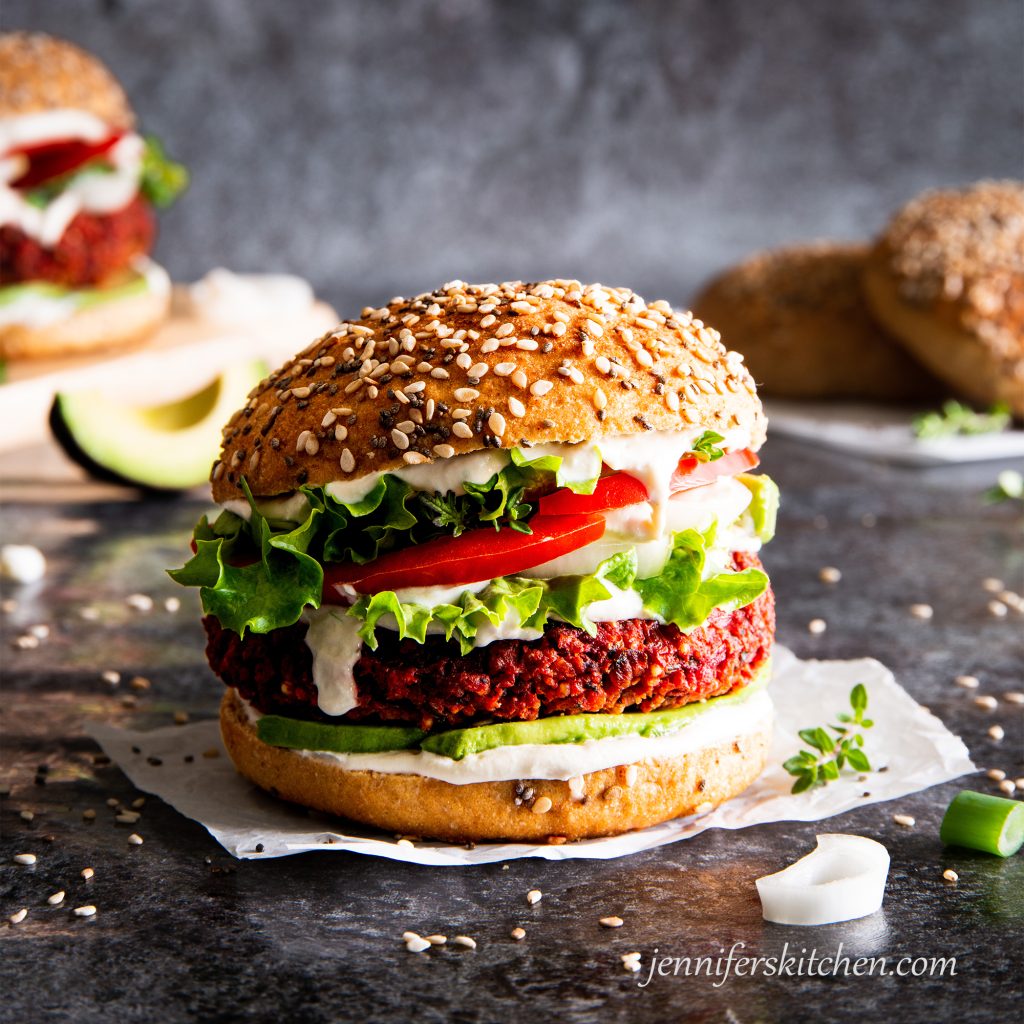 Gluten-free, oil-free beet burger on a bun with toppings.