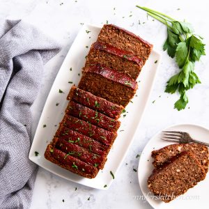 Gluten-free Quinoa Lentil No-Meatloaf on a platter with a plate served out on and ready to eat.