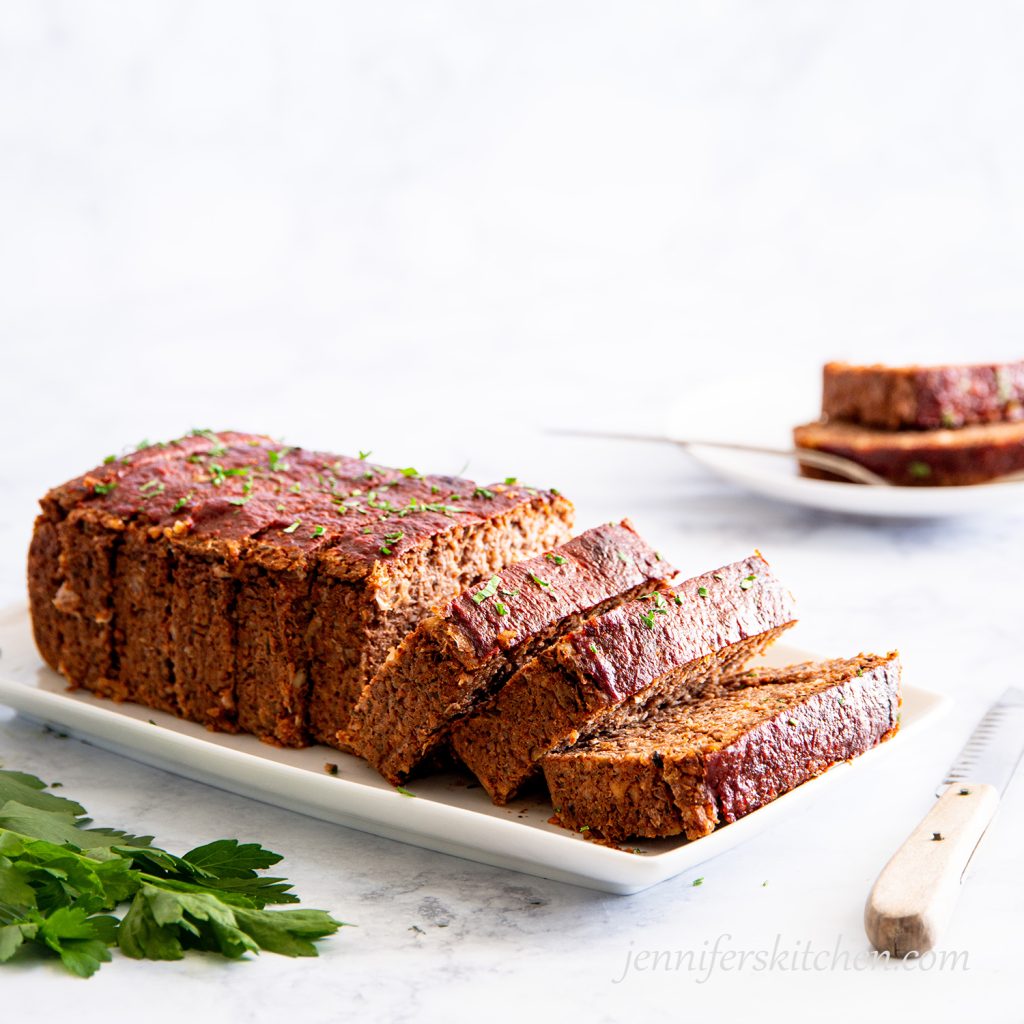 Gluten-free Quinoa Lentil No-Meatloaf on a platter, sliced and ready to serve.