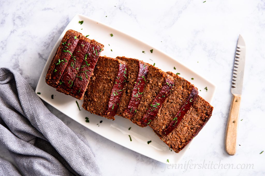 Gluten-free Quinoa Lentil No-Meatloaf on a platter, sliced and ready to serve.