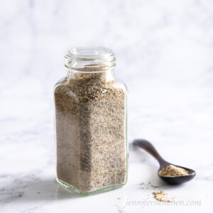 Nutritional yeast free chicky seasoning in a jar with a spoon beside.