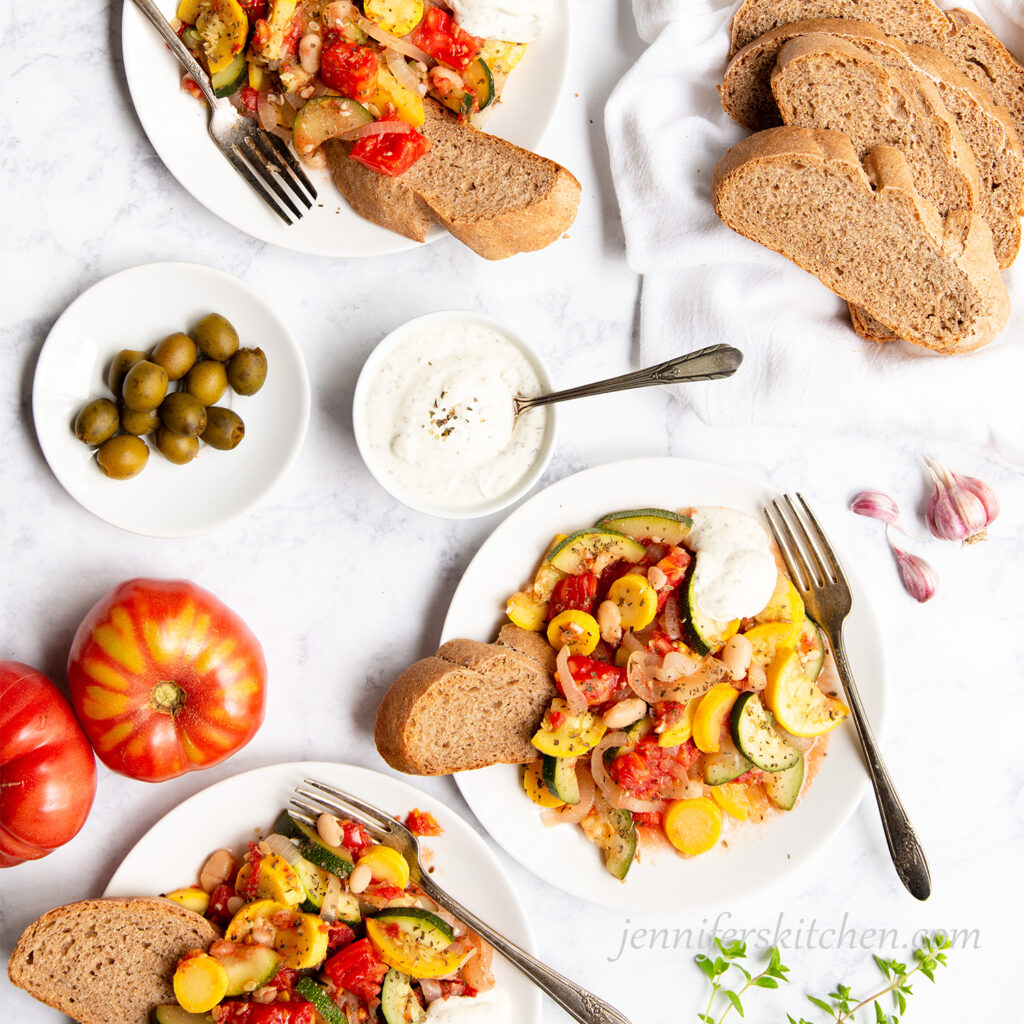 Summer Squash Sauté served on 3 plates with cashew dressing and whole-grain bread.
