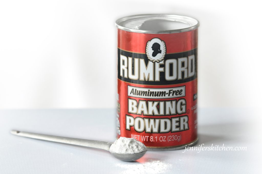 A can of baking powder with some on a spoon